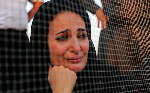 An Iraqi Kurdish woman mourns at the site of a mass grave of victims killed during the reign of ex-dictator Saddam Hussein, exhumed by the Baghdad-based Medico-Legal Directorate, at a mass grave site in the southern province of Mutahanna, on July 30, 2019. - Credit: HAIDAR HAMDANI/AFP