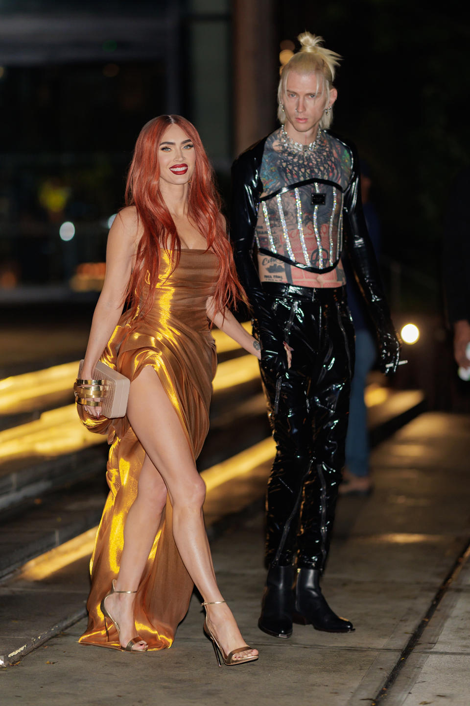 The actress wore a figure-hugging gold dress with a thigh-high split as she posed alongside her fiancé Machine Gun Kelly, who was being honoured at the event. Photo: Getty
