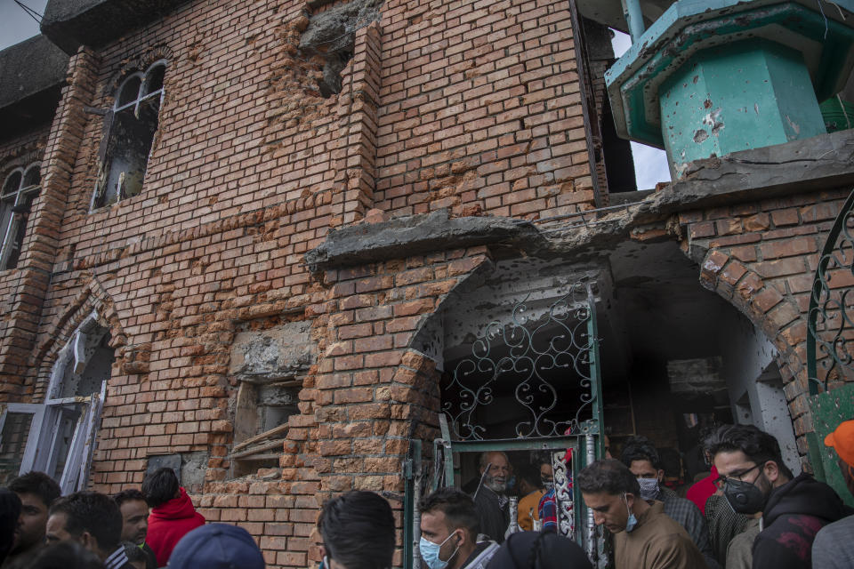 Kashmiri villagers inspect a mosque partially damaged during a gunbattle between Indian soldiers and suspected militants in Shopian, south of Srinagar, Indian controlled Kashmir, Friday, April 9, 2021. Seven suspected militants were killed and four soldiers wounded in two separate gunfights in Indian-controlled Kashmir, officials said Friday, triggering anti-India protests and clashes in the disputed region. (AP Photo/ Dar Yasin)
