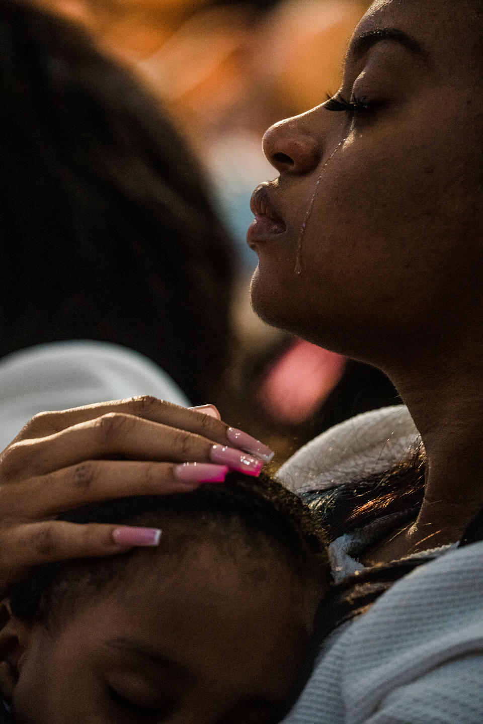 Charon Reed holds her son Koda and cries at the funeral of her grandmother, one of 10 killed in the racist massacre at a Tops grocery store, in Buffalo, N.Y., on May 24.<span class="copyright">Gabriela Bhaskar—The New York Times/Redux</span>
