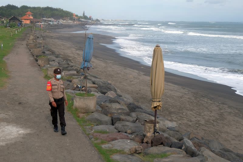 A police officer patrols at an empty beach amid the coronavirus disease (COVID-19) outbreak, in Badung, Bali