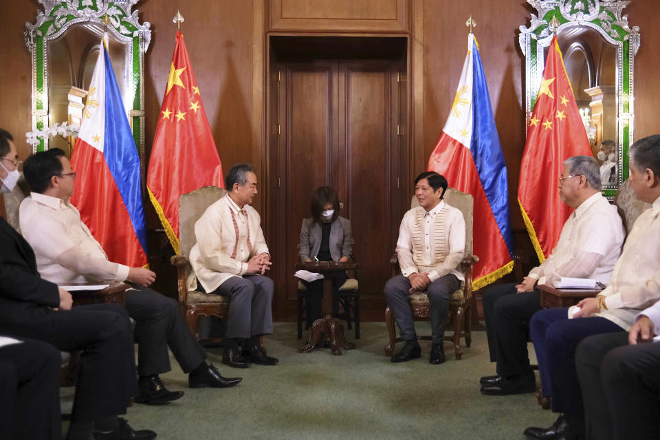 In this handout photo provided by the Malacanang Presidential Photographers Division, Philippine President Ferdinand Marcos Jr., center, talks with Chinese Foreign Minister Wang Yi during a courtesy call at the Malacanang Presidential Palace in Manila, Philippines on Wednesday, July 6, 2022. (Malacanang Presidential Photographers Division via AP)