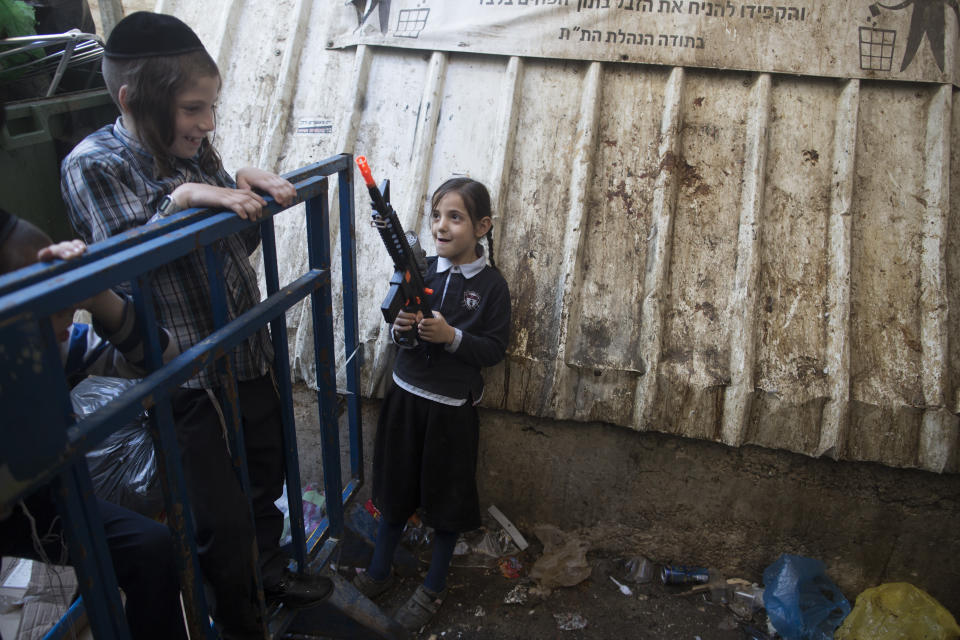 <p>An ultra-Orthodox Jewish girl holds a toy gun during the Kapparot ceremony on Sept. 27, 2017 in Jerusalem, Israel. It is believed that the Jewish ritual, which involves swinging a live chicken above one’s head, transfers the sins of the past year to the chicken, which is then slaughtered and traditionally given to the poor. It is performed before the Day of Atonement, or Yom Kippur, the most important day in the Jewish calendar, which this year will start on sunset on Sept. 29. (Photo: Lior Mizrahi/Getty Images) </p>