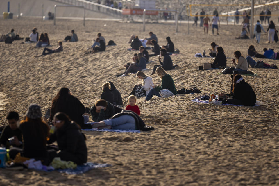People sunbathe on the beach in Barcelona, Spain, Friday, Jan. 26, 2024. Spain's weather agency says recent abnormally high temperatures for this time of year are set to continue in many parts of Spain on Friday and over the weekend, with an almost summer-like feeling in many coastal areas as people take to the beaches to sunbathe and some to have a winter swim(AP Photo/Emilio Morenatti)