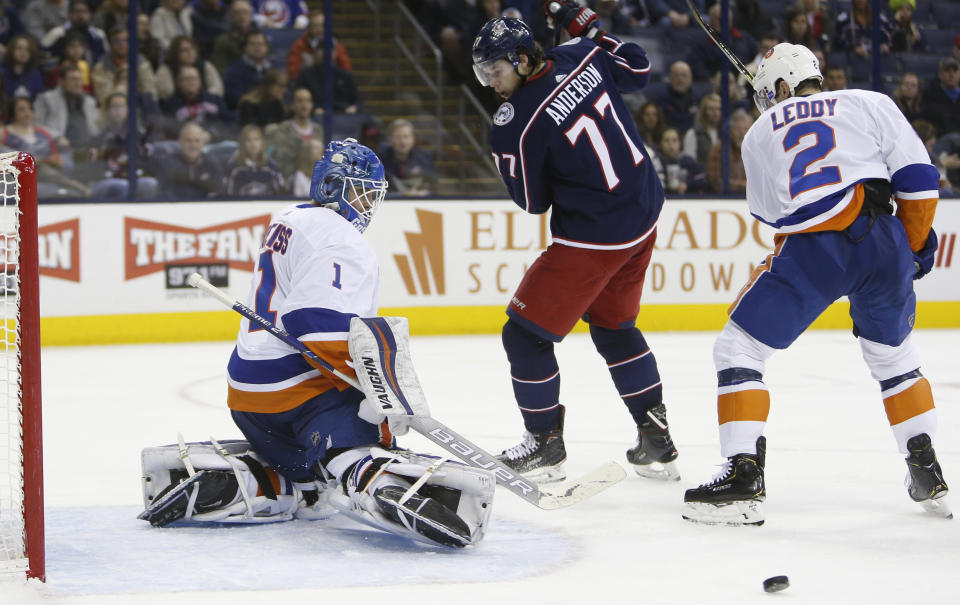 New York Islanders' Thomas Greiss, left, of Germany, makes a save as teammate Nick Leddy, right, and Columbus Blue Jackets' Josh Anderson look for the rebound during the second period of an NHL hockey game Thursday, Feb. 14, 2019, in Columbus, Ohio. (AP Photo/Jay LaPrete)