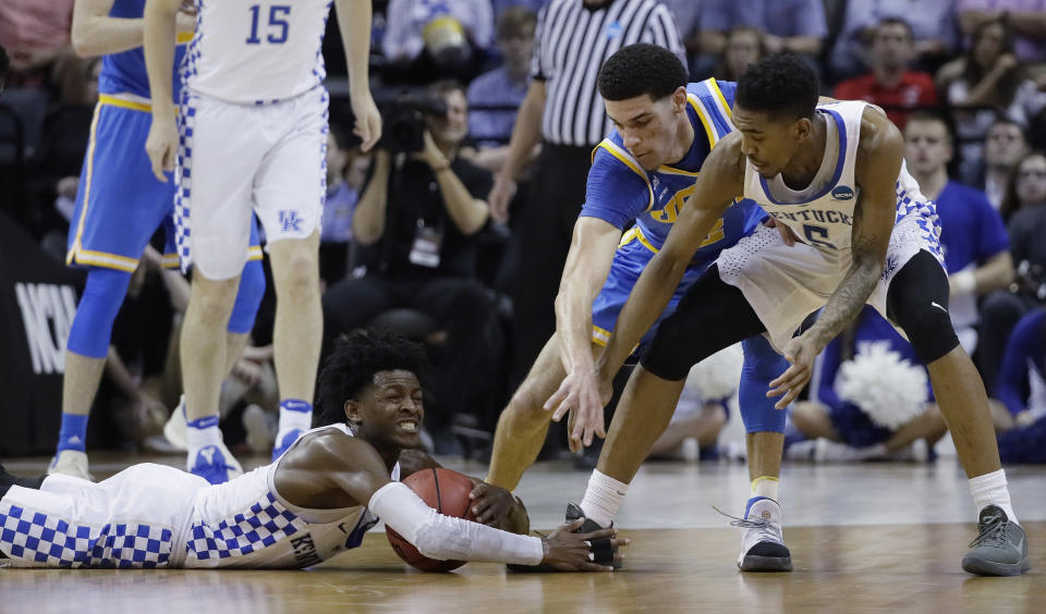 Kentucky guard De'Aaron Fox grabs the ball as UCLA guard Lonzo Ball and Kentucky guard Malik Monk look on in the second half of an NCAA college basketball tournament South Regional semifinal game Friday, March 24, 2017, in Memphis, Tenn. (AP Photo/Mark Humphrey)