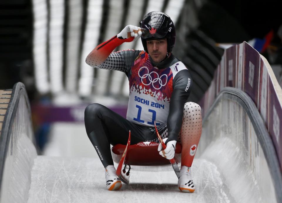 Canada's Edney adjusts his helmet after finishing a run during the men's singles luge competition at the 2014 Sochi Winter Olympics