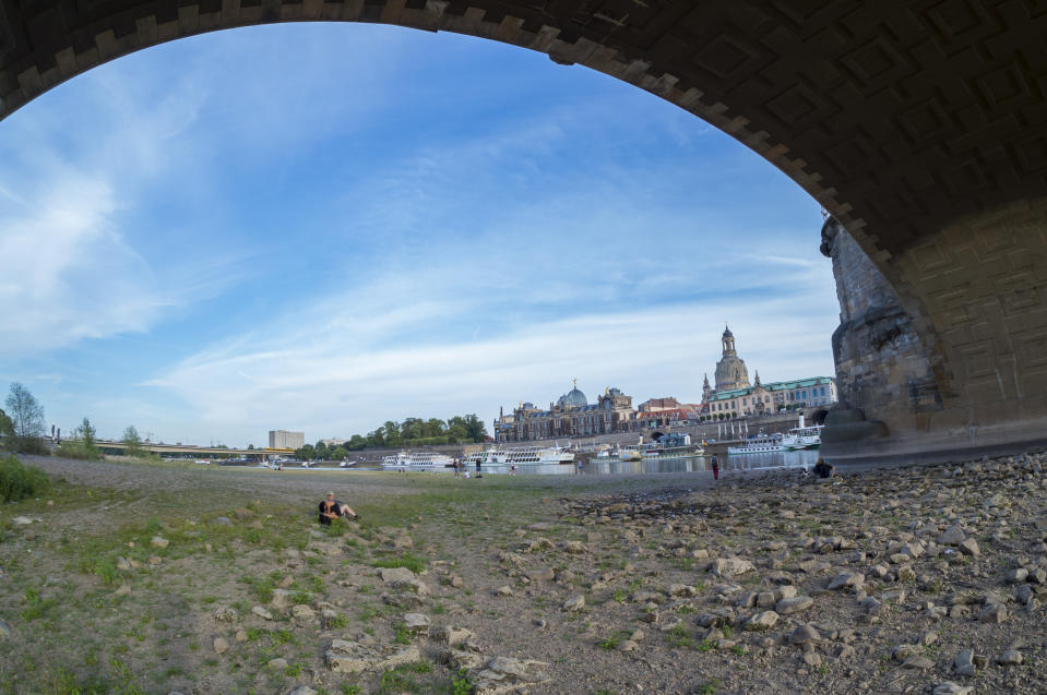 <p>A low water level of Elbe river is seen below Dresden’s old town district during hot weather on Aug. 7, 2018 in Germany. A heat wave and dry spell are persisting over Germany that this week is bringing temperatures to 38 degrees Celsius. Farmers are reporting plummeting harvests, while shrinking rivers are exposing munitions left over from World War II. (Photo: Matthias Rietschel/Getty Images) </p>