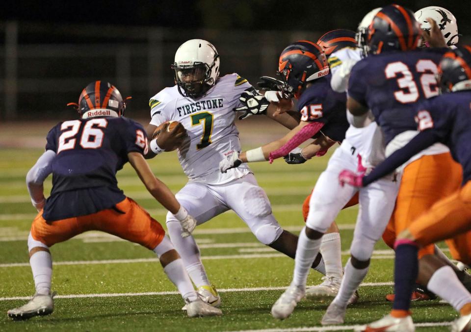 Firestone quarterback Prince Winchester, center, scrambles for yards during the second half of a football game against Ellet, Thursday, Oct. 7, 2021, in Akron, Ohio.