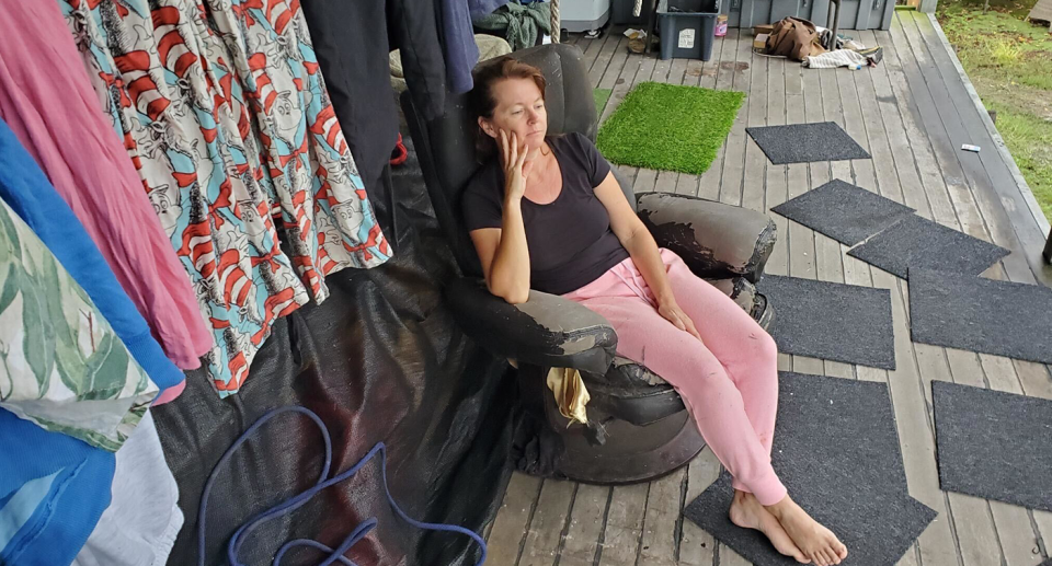 Deb Johnston sitting on the porch of her shed.