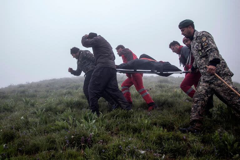 Los rescatistas recuperan cadáveres en el lugar del accidente de un helicóptero que transportaba al presidente de Irán, su ministro de Asuntos Exteriores y otras personas en una zona montañosa cubierta de niebla de Varzaghan, en el noroeste de Irán.