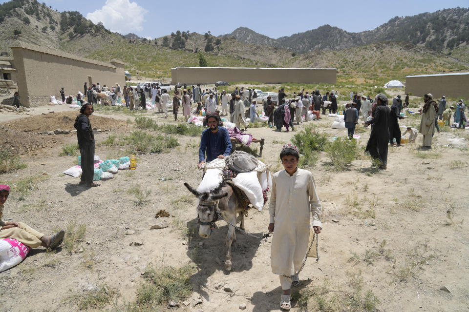 Afghans receive aid at a camp after an earthquake in Gayan district in Paktika province, Afghanistan, Sunday, June 26, 2022. A powerful earthquake struck a rugged, mountainous region of eastern Afghanistan early Wednesday, flattening stone and mud-brick homes in the country's deadliest quake in two decades, the state-run news agency reported. (AP Photo/Ebrahim Nooroozi)