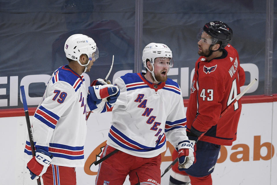 New York Rangers left wing Alexis Lafrenière, center, celebrates his goal with defenseman K'Andre Miller (79) next to Washington Capitals right wing Tom Wilson (43) during the third period of an NHL hockey game, Sunday, March 28, 2021, in Washington. (AP Photo/Nick Wass)