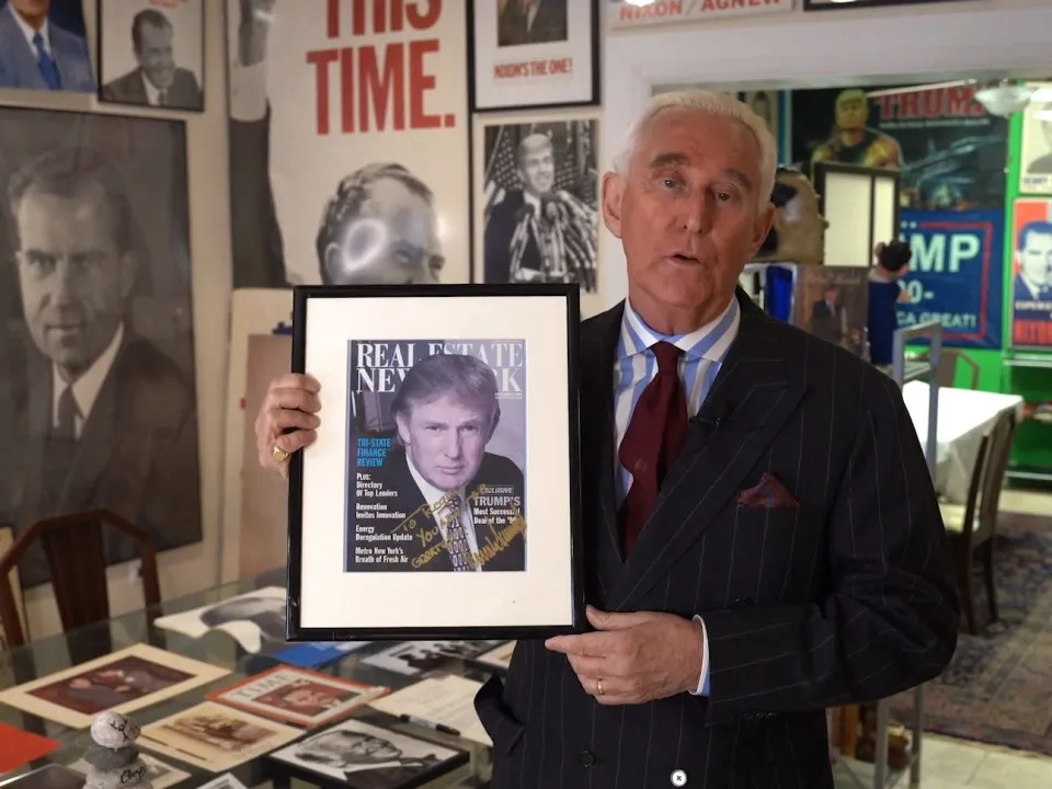 Roger Stone holds up an autographed print of former President Donald Trump.