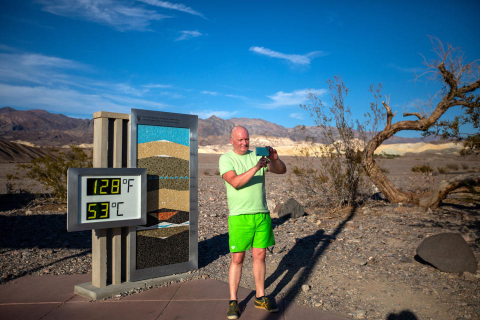 Image: A visitor takes a selfie next to the National Park Furnace Creek outdoor thermometer in Death Valley, Calif., on July 16. (Francine Orr / Los Angeles Times via Getty Images file)