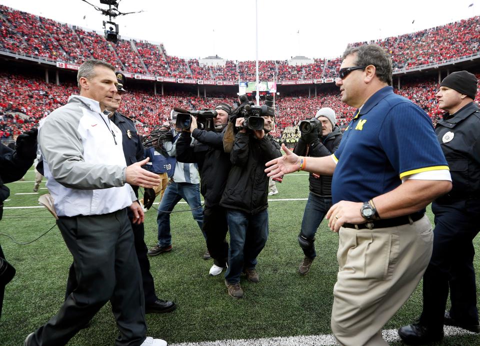 Ohio State Buckeyes head coach Urban Meyer goes to shake hands with Michigan Wolverines head coach Brady Hoke following the NCAA football game at Ohio Stadium on Nov. 29, 2014. The Buckeyes won 42-28. (Adam Cairns / The Columbus Dispatch)