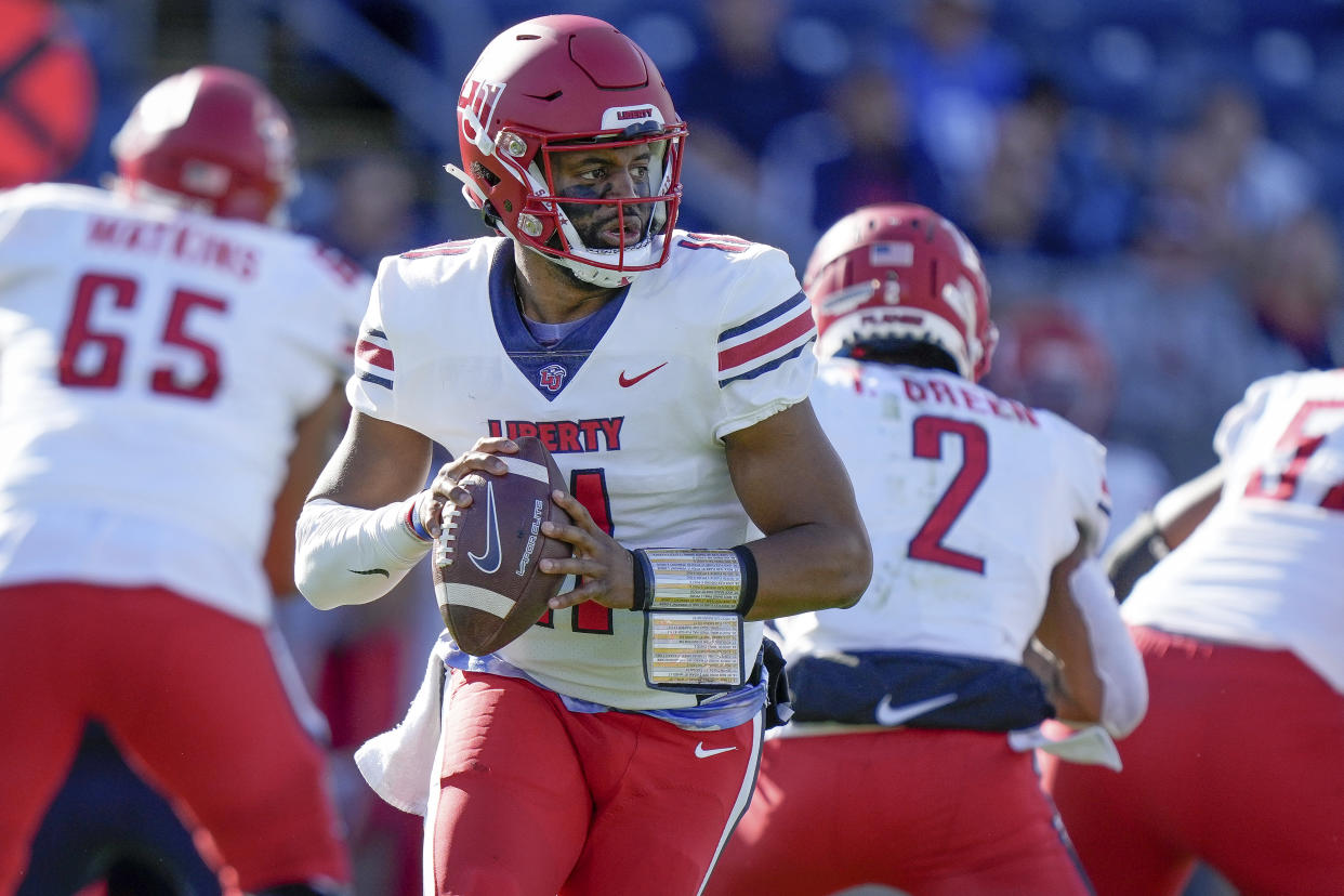 Liberty quarterback Johnathan Bennett (11)scrambles with the ball during the first half of an NCAA college football game against Connecticut in East Hartford, Conn., Saturday, Nov. 12, 2022. (AP Photo/Bryan Woolston)