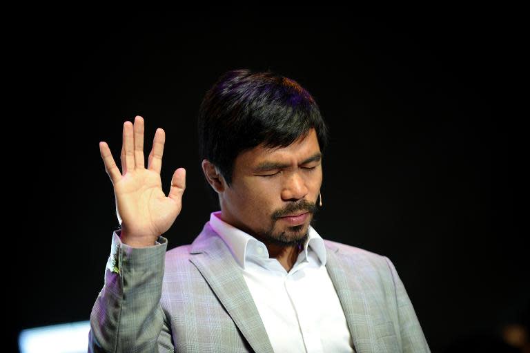Philippine boxing icon Manny Pacquiao gestures during a prayer rally at the Araneta Coliseum in Manila on July 28, 2012