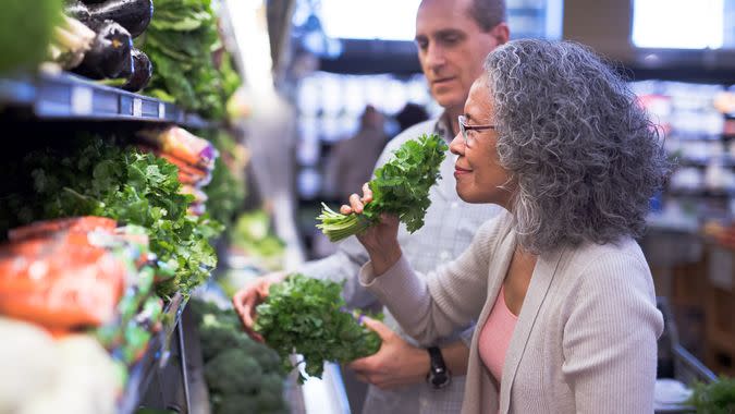 A multi-ethnic senior couple is in a grocery store shopping together.