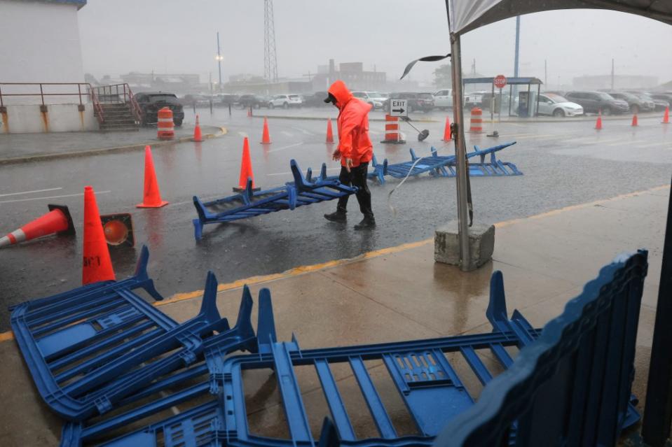 A worker attempting to collect barricades blown away by the storm at the Brooklyn Cruise Terminal on May 23, 2024. REUTERS/Andrew Kelly