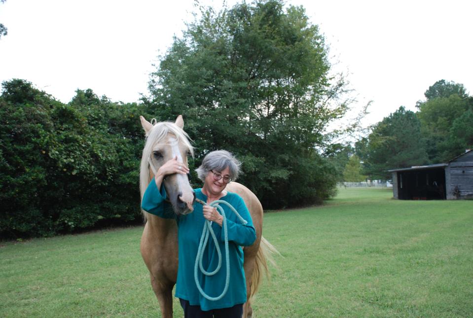 Nancy West stands at her home in Rocky Mount, North Carolina, with the Morgan horse Goldie, short for Harvey's Golden Viking, that she inherited from her uncle, who raised Morgans in Clinton. West discovered that her three-times-great-grandfather worked as the foreman of a livery stable in Utica and, intrigued by the equine connection, she set out to find his grave.