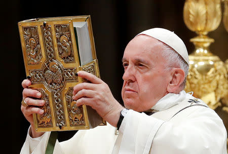 Pope Francis holds the Bible as he leads the Easter vigil Mass in Saint Peter's Basilica at the Vatican, April 20, 2019. REUTERS/Remo Casilli