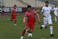 South Korea's Hwang Ui Jo, center, tries to pass from Iran's Saeid Ezatolahi during their final round of the Asian zone qualifying soccer match for the FIFA World Cup Qatar 2022 at Azadi Stadium in Tehran, Iran, Tuesday, Oct. 12, 2021. (AP Photo/Vahid Salemi)