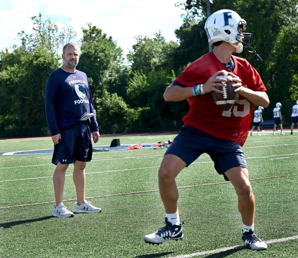 Franklin football coach Eian Bain watches as quarterback Justin Bianchetto drops back for a pass during the first day of practice, Aug. 19, 2022.