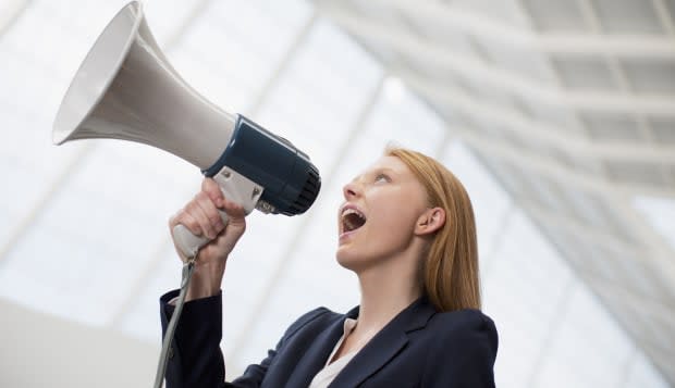 Businesswoman shouting into bullhorn