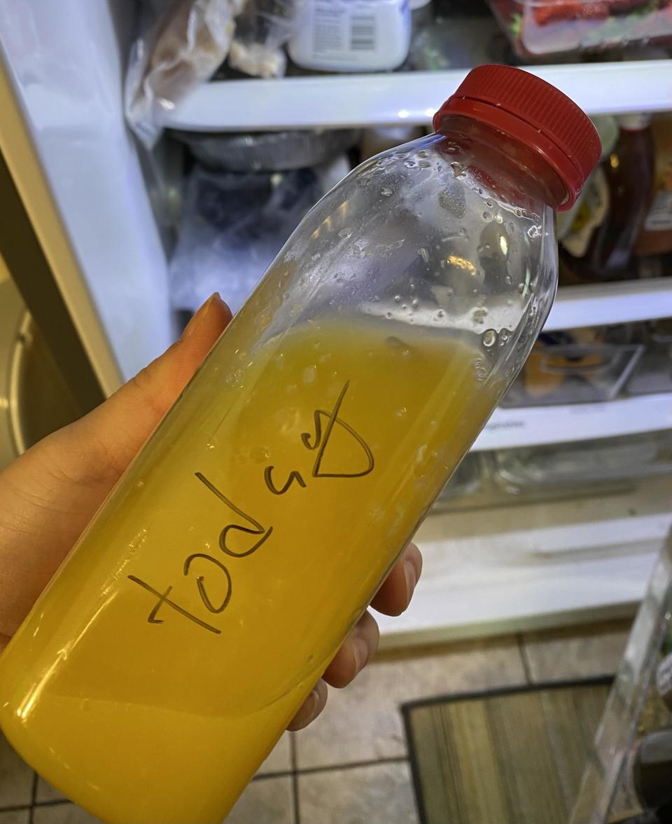 Hand holding a plastic bottle with handwritten "today" on it