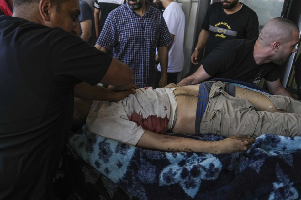 An injured Palestinian is carried into a hospital during an Israeli military raid in the Jenin refugee camp, a militant stronghold in the occupied West Bank, Monday, July 3, 2023. Israeli drones struck targets in the area early Monday and hundreds of troops were deployed. Palestinian health officials said at least five Palestinians were killed. (AP Photo/Nasser Nasser)