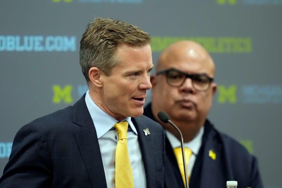 University of Michigan new NCAA college basketball head coach Dusty May addresses the media as Athletic Director Warde Manuel looks on during a news conference, Tuesday, March 26, 2024, in Ann Arbor, Mich. (AP Photo/Carlos Osorio)