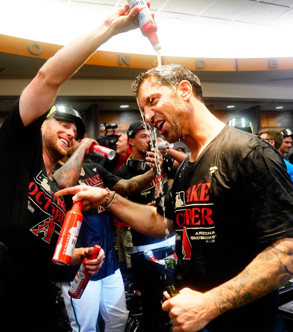 Arizona Diamondbacks starting pitcher Merrill Kelly pours beer over general manager Mike Hazen during celebrations after clinching a wild-card playoff spot following their game with the Houston Astros at Chase Field in Phoenix on Sept. 30, 2023.