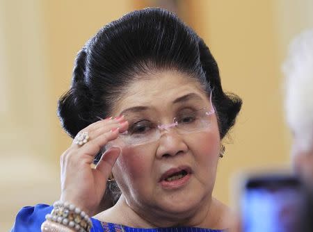 Former Philippine first lady Imelda Marcos, who is now a congresswoman, adjusts her glasses after attending the first Mass of the newly built Santuario de San Ezekiel Moreno Catholic church in Las Pinas city, south of Manila, August 19, 2014. REUTERS/Romeo Ranoco