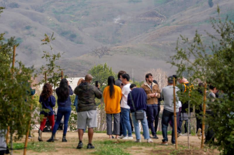 Spectators gather near the scene of a helicopter crash that reportedly killed retired basketball star Kobe Bryant in Calabasas