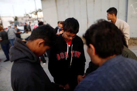 Members of a migrant caravan from Central America pray in preparation for an asylum request in the U.S., in Tijuana, Baja California state, Mexico April 28, 2018. REUTERS/Edgard Garrido