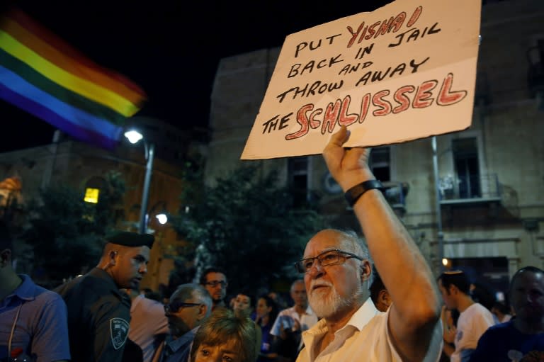 A man holds a placard as thousands of Israelis gather in downtown Jerusalem on August 1, 2015 to protest against discrimination and violence against the gay community