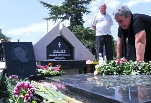 Georgian woman cries over a tomb at a memorial cemetry in Tbilisi as Georgians mark the anniversary of the Ossetian conflict. Russian President Vladimir Putin said on Wednesday that Russia had had a contingency plan for a war with Georgia and even trained militiamen in the breakaway region of South Ossetia