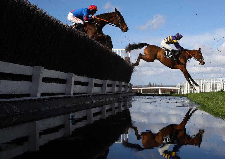 Derek Fox (r) riding Corach Rambler takes the water jump on his way to winning  the Ultima Handicap Chase (Getty Images)