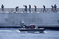 Mock suspects are escorted by armed Philippine Coast Guard personnel on board the PCG Melchora Aquino ship during a Coast Guard drill off the waters of Bataan, Philippines, Tuesday, June 6, 2023. U.S., Japan and Philippine coast guard ships staged law enforcement drills in waters near the disputed South China Sea on Tuesday as Washington pressed efforts to reinforce alliances in Asia amid an increasingly tense rivalry with China.(AP Photo/Aaron Favila)