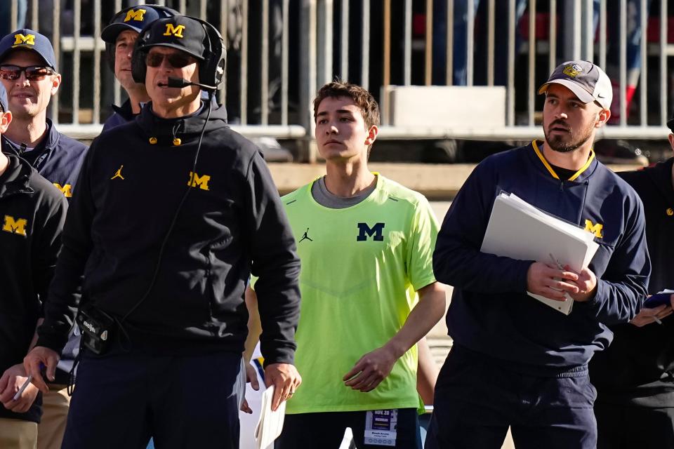 November 26, 2022; Columbus, Ohio, USA; Michigan Wolverines head coach Jim Harbaugh watches from the sideline alongside off-field analyst Connor Stalions, right, during the NCAA football game against the Ohio State Buckeyes at Ohio Stadium.