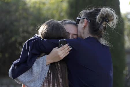 People embrace near the Tocqueville high school after a shooting has taken place in Grasse, southern France, March 16, 2017. REUTERS/Eric Gaillard