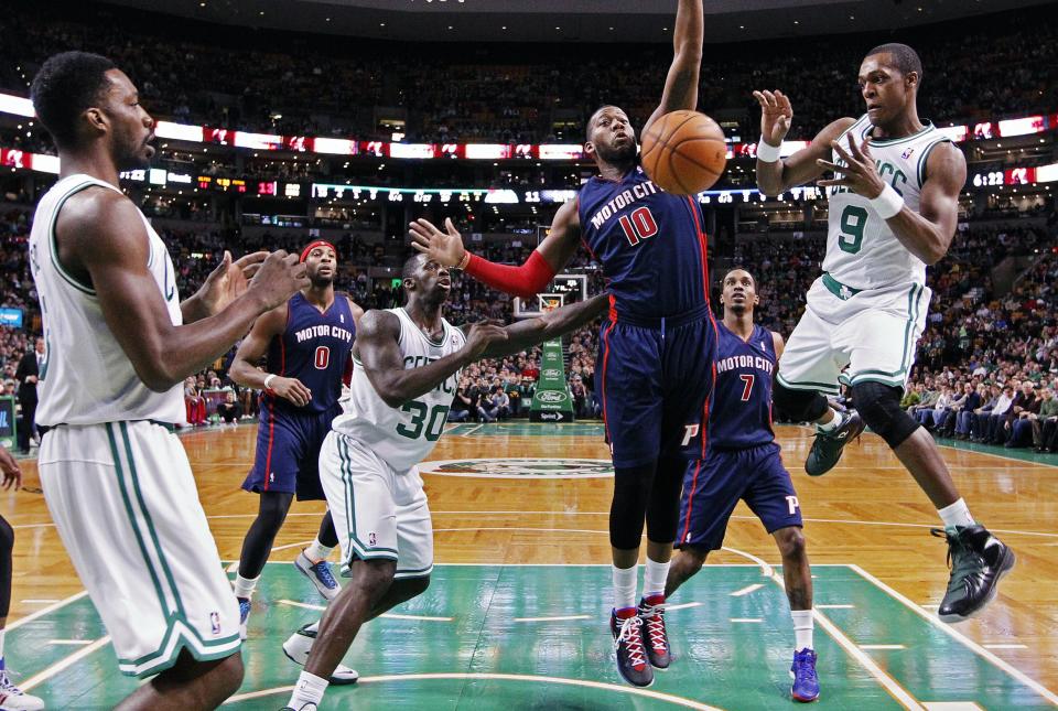 Boston Celtics' Rajon Rondo (9) passes in front of Detroit Pistons' Greg Monroe (10) in the first quarter of an NBA basketball game in Boston, Sunday, March 9, 2014. (AP Photo/Michael Dwyer)