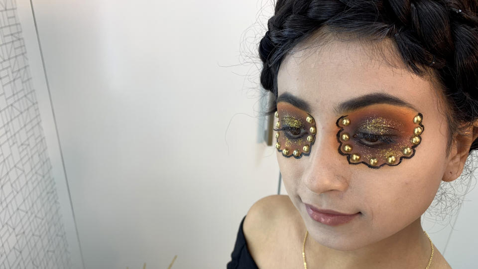 Rodriguez uses black eyeliner to make a flower pattern around her eyes and adds gold gems. (Photo: Gisselle Bances)