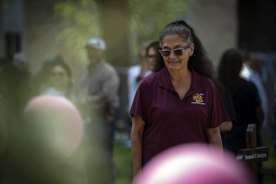 Josie Albrecht, a school bus driver, visits a memorial site for those killed in a mass shooting at Robb Elementary School, Sunday, May 29, 2022, in Uvalde, Texas. Albrecht had planned a pizza party to celebrate that afternoon. But before she could pick the students up and drive them home, a gunman walked into their school and started shooting. (AP Photo/Wong Maye-E)