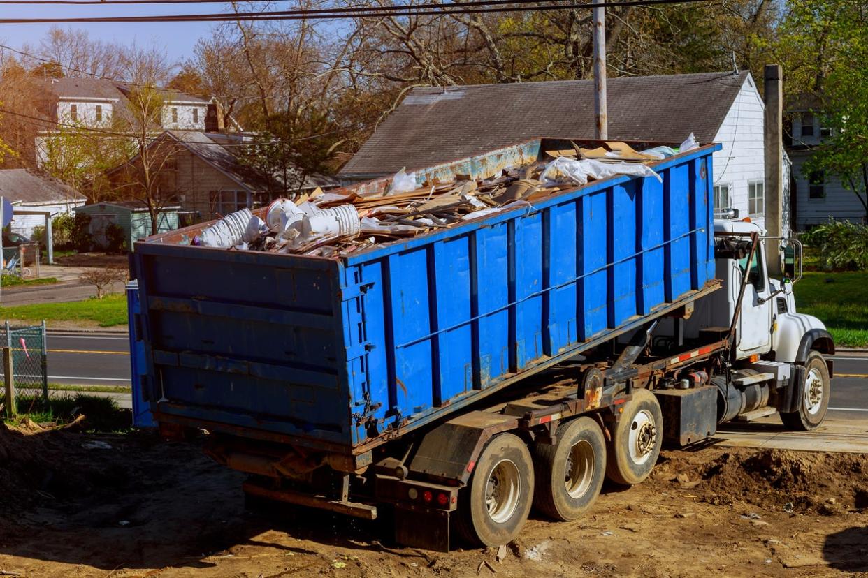 Removing a junk dumpster after a renovation project.