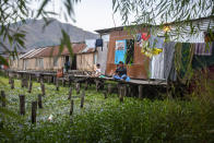 Kashmiri's fish outside their shanty over the Dal Lake in Srinagar, Indian controlled Kashmir, Thursday, Sept. 16, 2021. Dal Lake appears pristine in the area where hundreds of exquisitely decorated houseboats bob on its surface for rent by tourists and honeymooners. But farther from shore, the lake is a mixture of mossy swamps, thick weeds, trash-strewn patches and floating gardens made from rafts of reeds. (AP Photo/Mukhtar Khan)