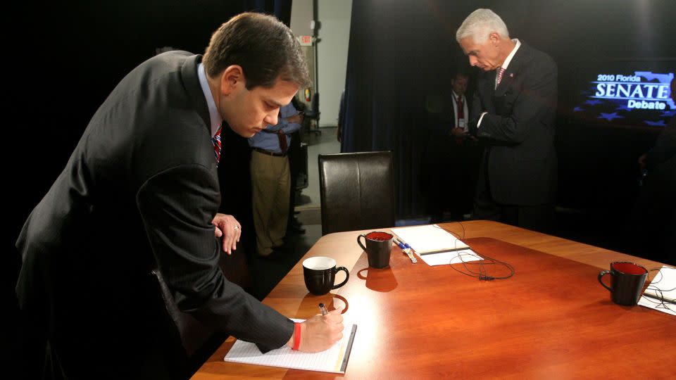 Then US-Senate candidates Marco Rubio, left, and Charlie Crist wait on Kendrick Meek to arrive before the start of their debate, at the studios of WFTV, Wednesday, October 6, 2010 in Orlando, Florida. - Joe Burbank/Pool/AP