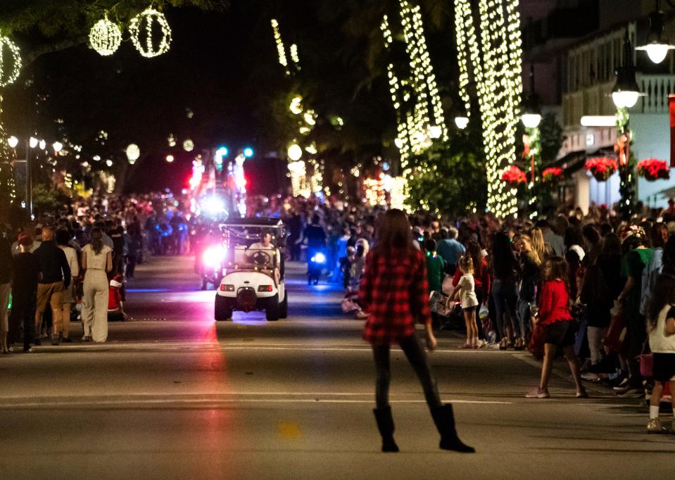 People watch as floats come into view during the Fifth Avenue South Christmas parade in Naples on Tuesday, Dec. 5, 2023.