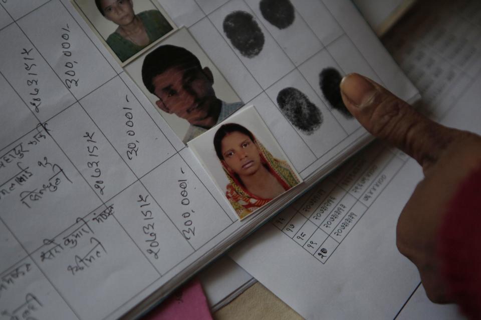 In this Tuesday, Dec 20, 2016 photo, Saro Kumari Mandal, 26, gives her fingerprint to receive compensation from the Foreign Employment Promotion Board after her husband died as a migrant worker in Qatar, in Kathmandu, Nepal. She received $2,777 which she said she would use to open a small store in the village selling cookies and noodles, and also invest in a sewing machine. She wants to earn money for their son's education. "I want to make my son a teacher or a doctor when he grows up," she said. (AP Photo/Niranjan Shrestha)